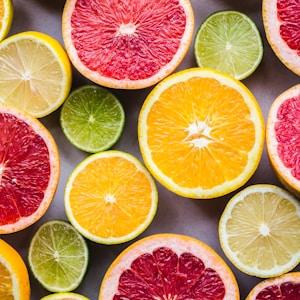 flat lay photography of sliced pomegranate, lime, and lemon